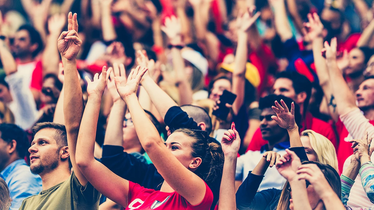 Crowds cheering on a sports stadium