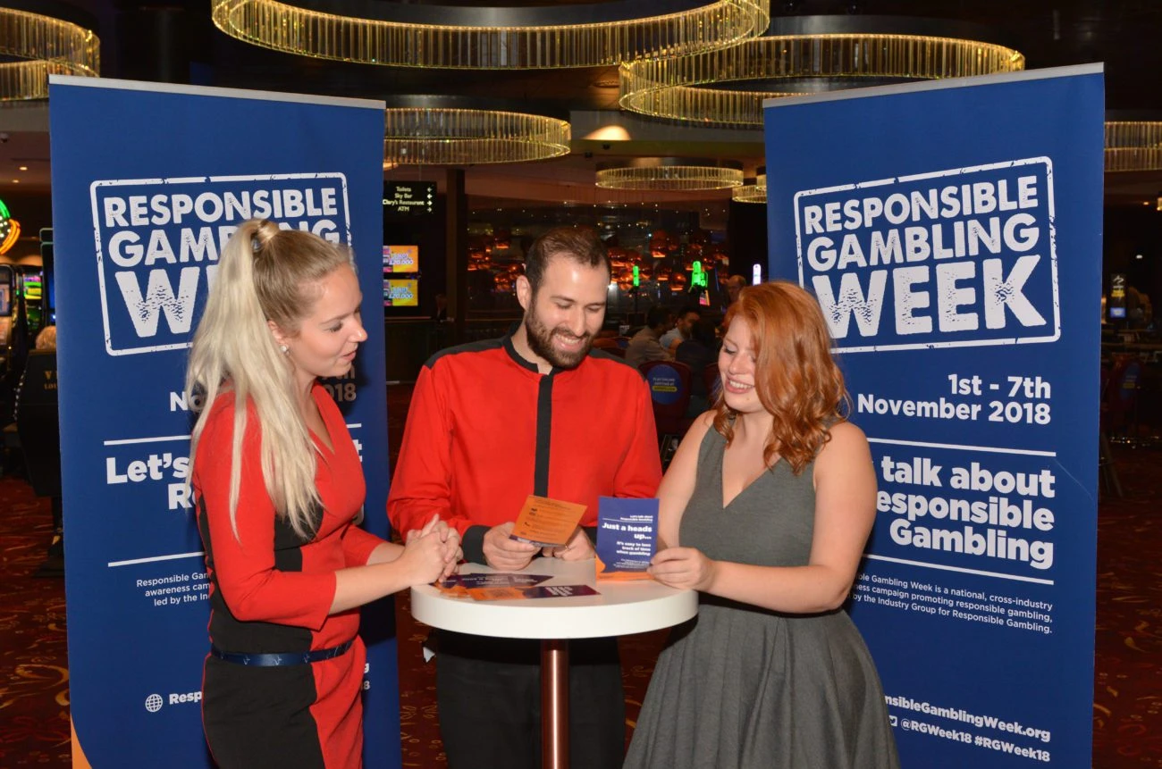 people at table responsible gambling week sign